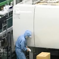 白い成形機と作業者