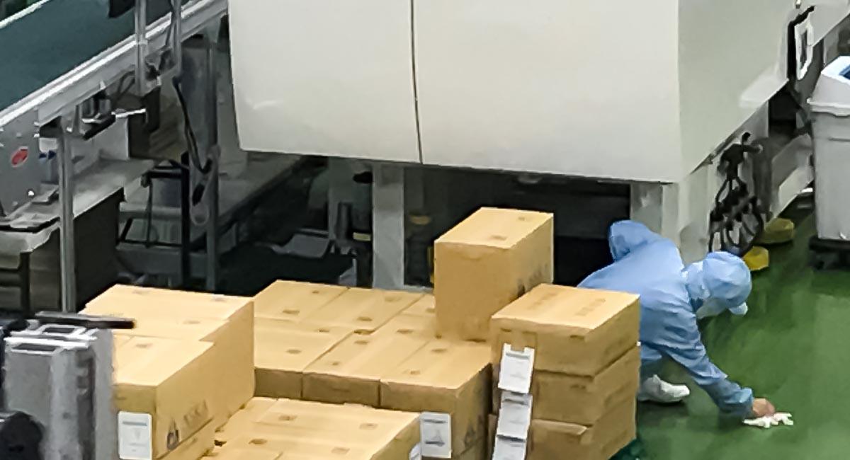 成形機場の床面の汚れをぬぐう